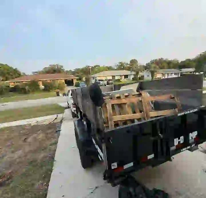 Haul & Gone dump trailer loaded with pallets and yard debris at a Jacksonville home
