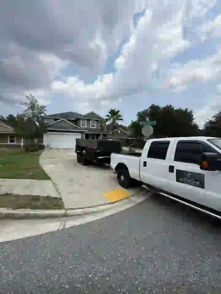 Haul & Gone Ford F-250 and dump trailer parked at a customer's driveway